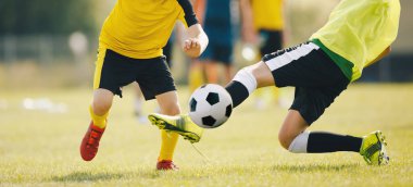 Futbol maçında slayt tutuşu. İki Genç Futbolcu Top İçin Yarışacak. Genç Oyuncular Yaz Güneşli Gününde Futbol Oynuyor