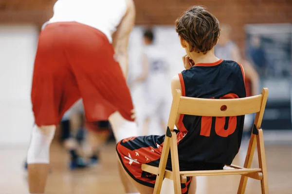 Молодой Баскетболист Наблюдает Тренировками Баскетболу Мальчик Сидит Деревянном Стуле Отдыхает — стоковое фото