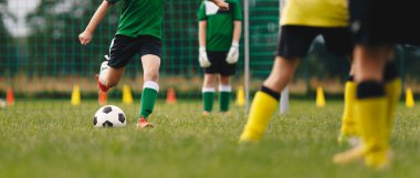 Çocuklar dışarıda futbol oynuyor. Bir grup isimsiz çocuk klasik futbol topunu tekmeliyor. Yaz kampında futbol maçı.