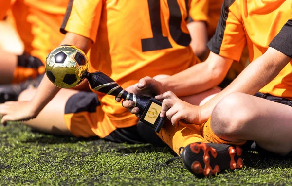 ハンドサッカートロフィー賞を受賞したスポーツウェアを着た少年 最も価値のある選手賞を持つサッカー少年 — ストック写真