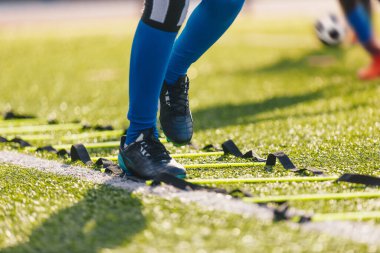 Antrenmanda genç bir futbolcu. Antrenman sırasında hızlı koşan futbolcu.