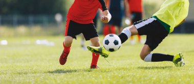 Slayt müdahalesi sırasında futbolcu hareket halinde. Yarışmada iki futbolcu. Antrenman maçına katılan oyuncular arasında futbol düellosu