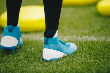 Futbol sahası kramponlarında antrenman yapan futbolcu. Antrenmanda futbol sahası kramponları giyen futbolcu.