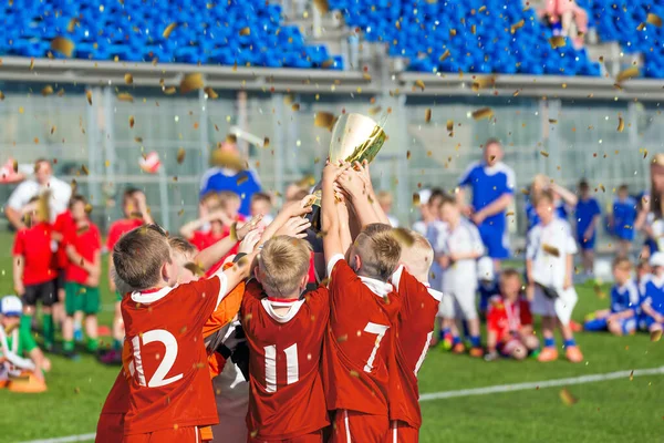 Spor Takımı Galibiyet Şampiyonası 'nda Okul Çocukları. Mutlu Çocuk Tutma ve Yükselen Altın Kupa. Erkekler Spor Turnuvasında Başarı Kutlaması. Futbol Stadyumunda Gençlik Spor Yarışması Oyunları