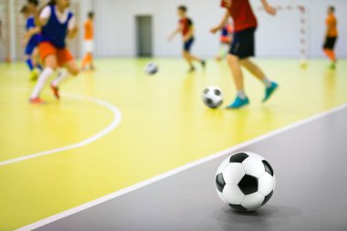 Çocuklar için kapalı futbol antrenmanı. Futbol becerileri eğitimi. Spor salonunda antrenman yapan Futsal oyuncular