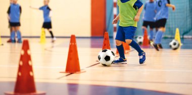 Futsal Eğitimdeki Çocuklar. Okul Spor Salonundaki Çocuklar İçin Kapalı Futbol Sınıfı. Çocuklar Futsal Zeminde Futbol Toplarını Tekmeliyor 