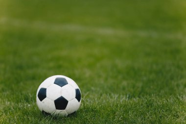 Antrenman sahasında klasik futbol topu. Futbol Doğal Çim Bölgesi. Bulanık Arkaplan 'daki futbol stadyumu. Genç Oyuncular Arka planda Egzersiz Yapıyor