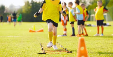 Antrenmandaki çocuk futbolcu. Antrenman seansında genç futbolcular. Agility Merdiven Tatbikatı 'nda Koşan Çocuklar. Futbol Akademisi Yaz Kampı 'nda Futbol Merdiveni Egzersizleri