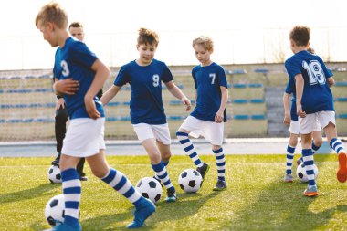 Futbol kampı için çocuklar. Çocuklar pratik bir alanda top sürme. Oyuncular iyi futbol top sürme becerileri geliştirmek. Çocuk eğitim topları ve koniler ile. Futbol slalom matkaplar futbol top sürme hızını artırmak için