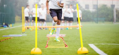 Gençler için Futbol Antrenmanı. Sahada Çocuklar Futbol Antrenmanı. Arka plandaki futbol stadyumu. Genç Futbolcular Açık havada Güç ve Çeviklik Yeteneklerini Geliştiriyor