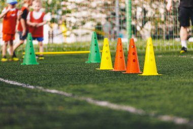 Beden Eğitiminde Çocuklar Açık Hava Eğitim Dersi. Çocuklar için Spor Eğitim Ekipmanı. Spor Konileri Sıraya Girsin ve Çocuklar Engelleri Koşmaya Hazır