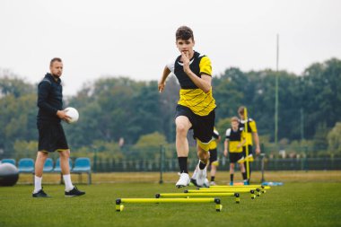 Genç Futbol Kulübü antrenman oturumu. Antrenman sahasında koşan genç sporcu. Gençler, Genç Koç 'la Futbol Eğitimi Spor Giyim' de. Spor Eğitimi Malzemeleri