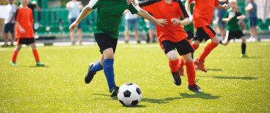 Genç çocuklar futbol oynuyor. Gençler futbol takımları arasında antrenman ve futbol maçı. Koşan oyuncular arasındaki küçük yarışma 