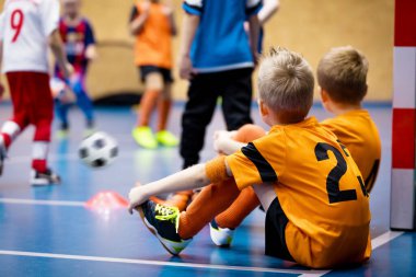 Futsal Eğitimdeki Çocuklar. Okul Spor Salonundaki Çocuklar İçin Kapalı Futbol Sınıfı. Çocuklar Futsal Zeminde Futbol Toplarını Tekmeliyor