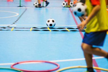 Çocuklar için kapalı futbol antrenmanı. Okul çocukları için beden eğitimi dersi. Çocuklar çevikliği geliştiriyor. Futbol becerileri eğitimi. Spor salonunda antrenman yapan Futsal oyuncular