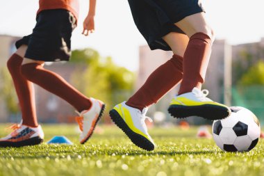 Futbol topuyla koşan tanınmamış futbolcular. Okul futbol takımında antrenman yapan bir çocuk. Futbol antrenmanındaki çocuklar. 