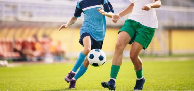 Futbolcular yarışmada topa vurur. Yetişkinlerin futbol maçı. İki takımdaki oyuncular top için yarışıyor. Futbolcular çimlerde koşuyor.