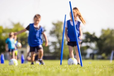 Sahada Futbol Eğitimi. Futbol antrenmanındaki oğlanlar ve kızlar. Top Koşan Çocuklar Futbolcuları. Güneşli bir günde futbol sahası. Futbol Stadyumu Arkaplanı 