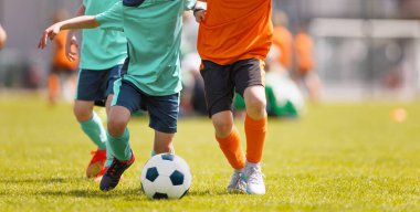 Güneşli bir günde Genç Futbolcular Gençler Maçı sırasında Top için yarışıyor