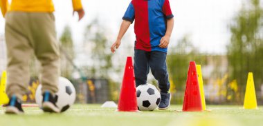 Genç Futbolcu Gençlik Sahasında Çalışırken Kırmızı ve Sarı Koniler Arasında Top Sürüklüyor