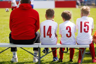 Gençlik Futbol Takımı Sidelines 'te Çocuklar Futbol formalarında Koç Çimen Sahasında Maç İzliyor