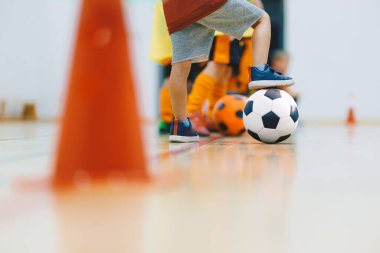 Çocuklar iç saha futbol antrenmanı. Spor Salonunda Top ve Konilerle Futbol Çalışması Yapan Çocuklar