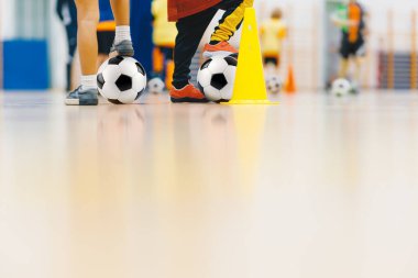 Çocuklar iç saha futbol antrenmanı. Genç Oyuncular Spor Salonunda Top Kontrolü ve Çeviklik Üzerinde Çalışıyor