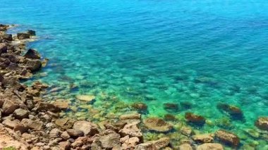 Resimli plaj, kumlu kıyıya vuran dalgalar. Deniz dalgaları kayalara çarpıyor. Kıbrıs Adası, Akdeniz.