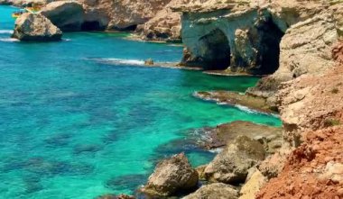 Resimli plaj, kumlu kıyıya vuran dalgalar. Deniz dalgaları kayalara çarpıyor. Kıbrıs Adası, Akdeniz.