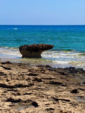 Resimli plaj, kumlu kıyıya vuran dalgalar. Deniz dalgaları kayalara çarpıyor. Kıbrıs Adası, Akdeniz.
