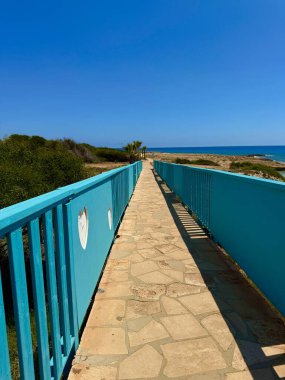 Resimli plaj, kumlu kıyıya vuran dalgalar. Deniz dalgaları kayalara çarpıyor. Kıbrıs Adası, Akdeniz.