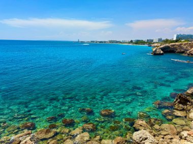 Resimli plaj, kumlu kıyıya vuran dalgalar. Deniz dalgaları kayalara çarpıyor. Kıbrıs Adası, Akdeniz.