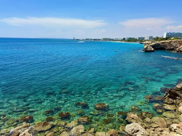 Resimli plaj, kumlu kıyıya vuran dalgalar. Deniz dalgaları kayalara çarpıyor. Kıbrıs Adası, Akdeniz.