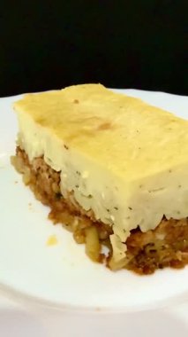Ev yapımı Pastitsio, bchamel kremalı lazanya. Yunan mutfağı, kıymalı lezzetli makarna, taze domates ve otlar. Etli fırında makarna ve biber sosu..