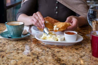 Taze, tuzlu ve tatlı soslu ev yapımı börek yiyen bir kadın.