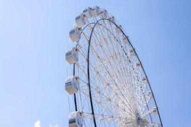 Yazın mavi gökyüzüne karşı beyaz renkli dönme dolap.