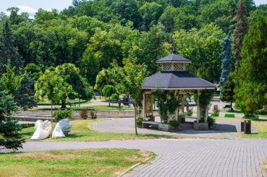 Vrnjacka Banja, Sırbistan - 25 Temmuz 2024: Vrnjacka Banja merkez parkındaki çardak güneşten korunuyor ve güller de dahil olmak üzere çiçeklerle kaplanıyor.