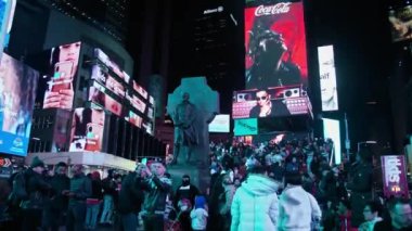 Manhattan, New York, ABD (1-27-2023): Yerli ve turist çeşitliliğinin canlı atmosferi, arka planda kırmızı TKTS tribünleri ile Peder Duffy Square tarafından Times Meydanı 'nda toplandı.