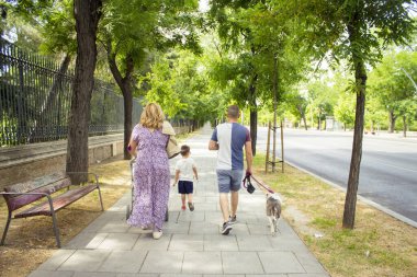 Aile sokaklarda yürüyor. Arkadan görülüyor. Gün sahnesi