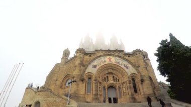 Bu, bir dağın tepesindeki güzel bir katedrale doğru yürüyen insanların görüntüleri ve bulutlar katedrali tamamen yemiş. Güzel yer..