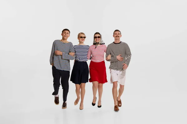 Stock image Group of four children young people, man and woman cheerfully walking isolated over white background. Concept of summer holidays, occupation, retro fashion, vintage style. Copy space for ad