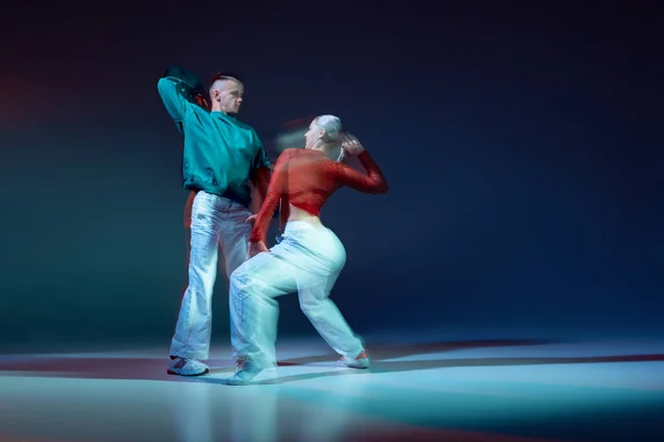 若い人たち 男と女の肖像は 混合光と濃い青の背景の上に孤立ヒップホップダンス 若者文化 アクティブライフスタイル アクション ストリートダンス 広告の概念 — ストック写真