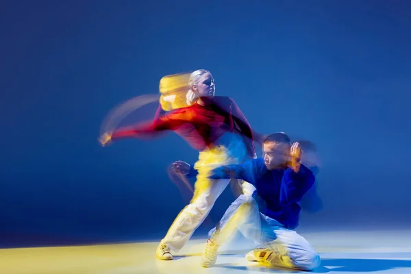 若い男性と女性の肖像は 混合光と濃い青の背景の上に孤立して踊る ブレイクダンス ヒップホップ 若者文化 アクティブライフスタイル アクション ストリートダンス 広告の概念 — ストック写真