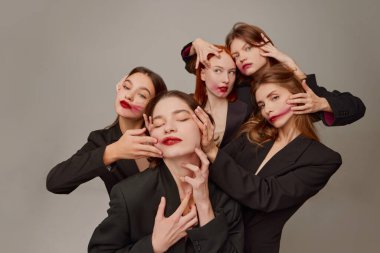 Siyah ceketli, kırmızı rujlu ve gri arkaplanda poz veren güzel kadınların portresi. Psikedelik. Güzellik kavramı, özgürlük, duygular, sıradışı moda, modern tarz, gençlik