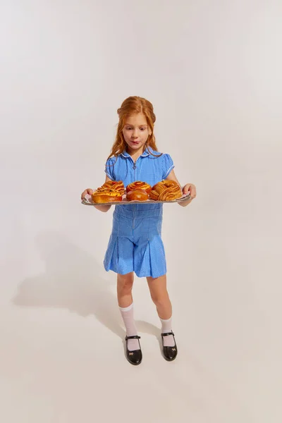 Portret Słodkiej Rudej Dziewczynki Dziecka Patrzącego Świeżo Upieczone Bułeczki Wyizolowane — Zdjęcie stockowe