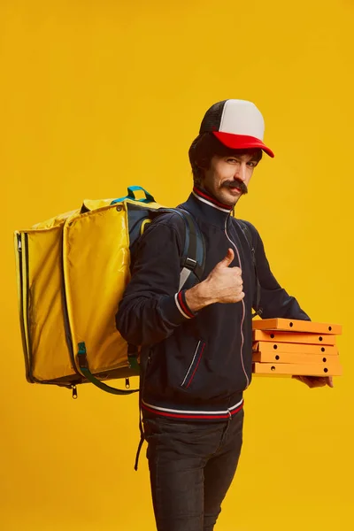一个留着胡子的送货员的画像 他摆出一副黄底披萨盒的姿势 食品递送业务 复古风格 面部表情 工作的概念 — 图库照片
