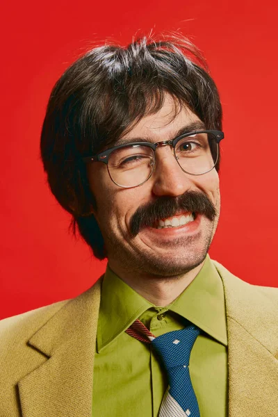 ヴィンテージスーツ姿の口髭を生やした男と 赤い背景に隔離された眼鏡のクローズアップ ウインクしてる レトロなスタイル 創造性 ファッション 職業の概念 — ストック写真