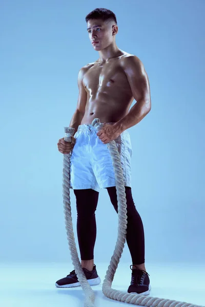 Портрет Молодого Мускулистого Человека Позирующего Веревкой Изолированной Синем Фоне Неоновом — стоковое фото