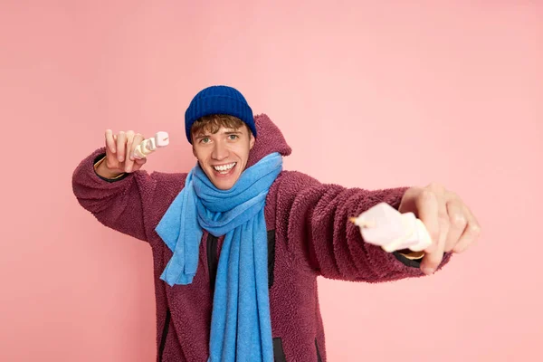 Портрет Счастливого Улыбающегося Молодого Человека Зимней Одежде Позирующего Зефиром Розовом — стоковое фото
