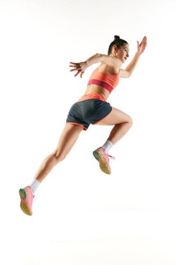 Arkadan bak. Sportif kaslı kadın, profesyonel koşucu beyaz arka planda tek başına kaçıyor. Spor, fitness, rekabet, hız ve aktif yaşam tarzı. İlan için alanı kopyala